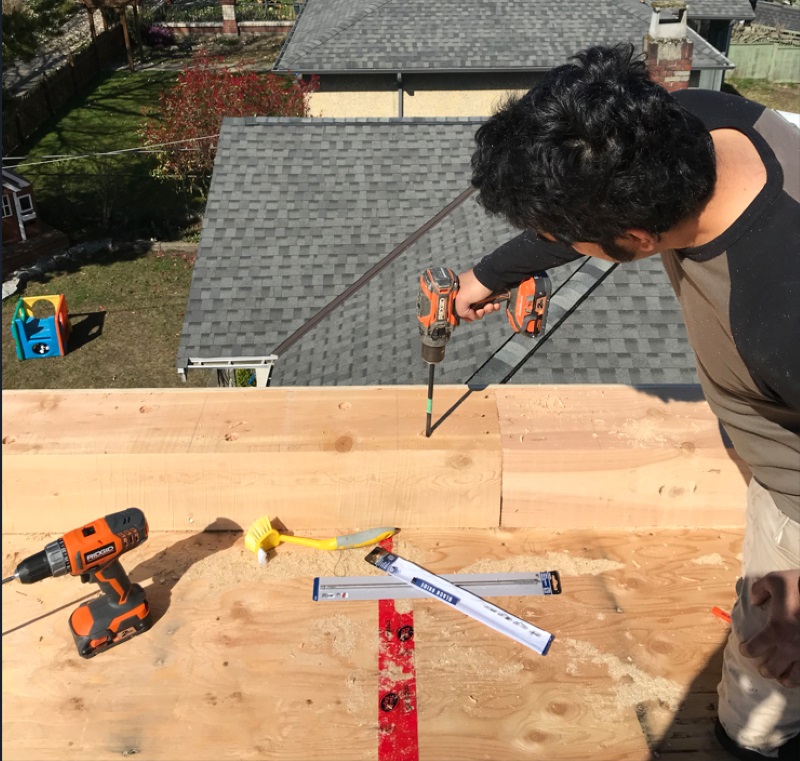 Rahul strengthening the rooftop beams using structural screws. Rahul working on rooftop